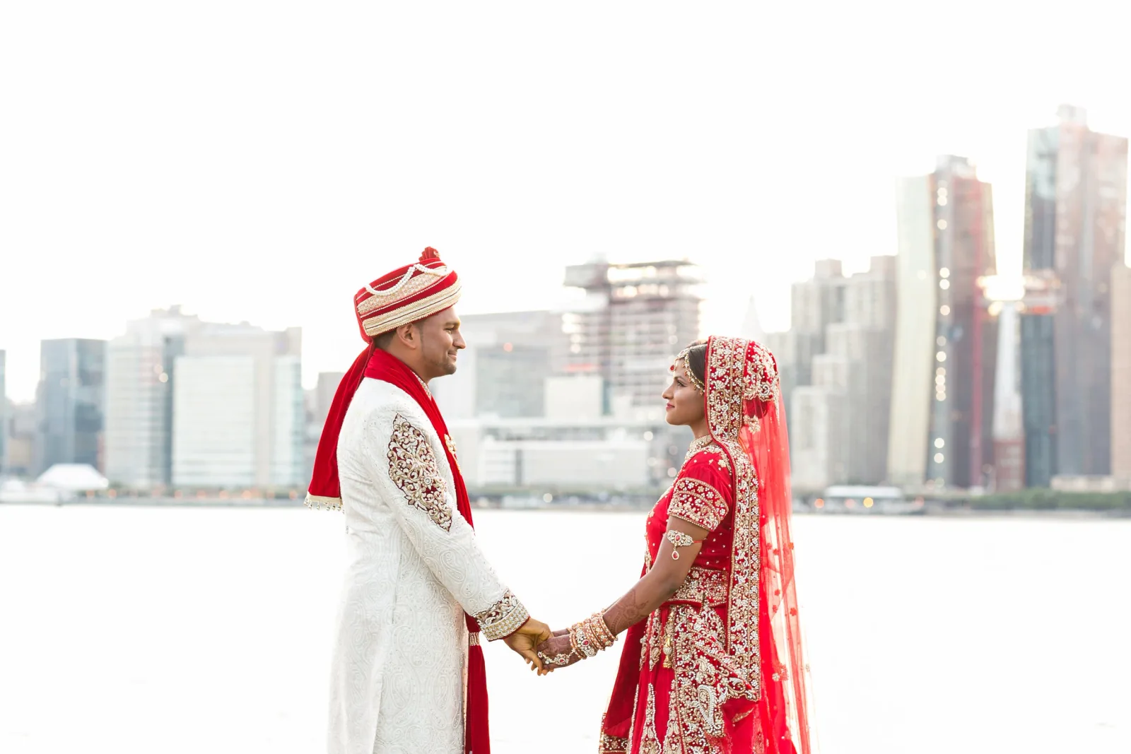 Sarah and Raj on the Long Island City waterfront, Manhattan behind them